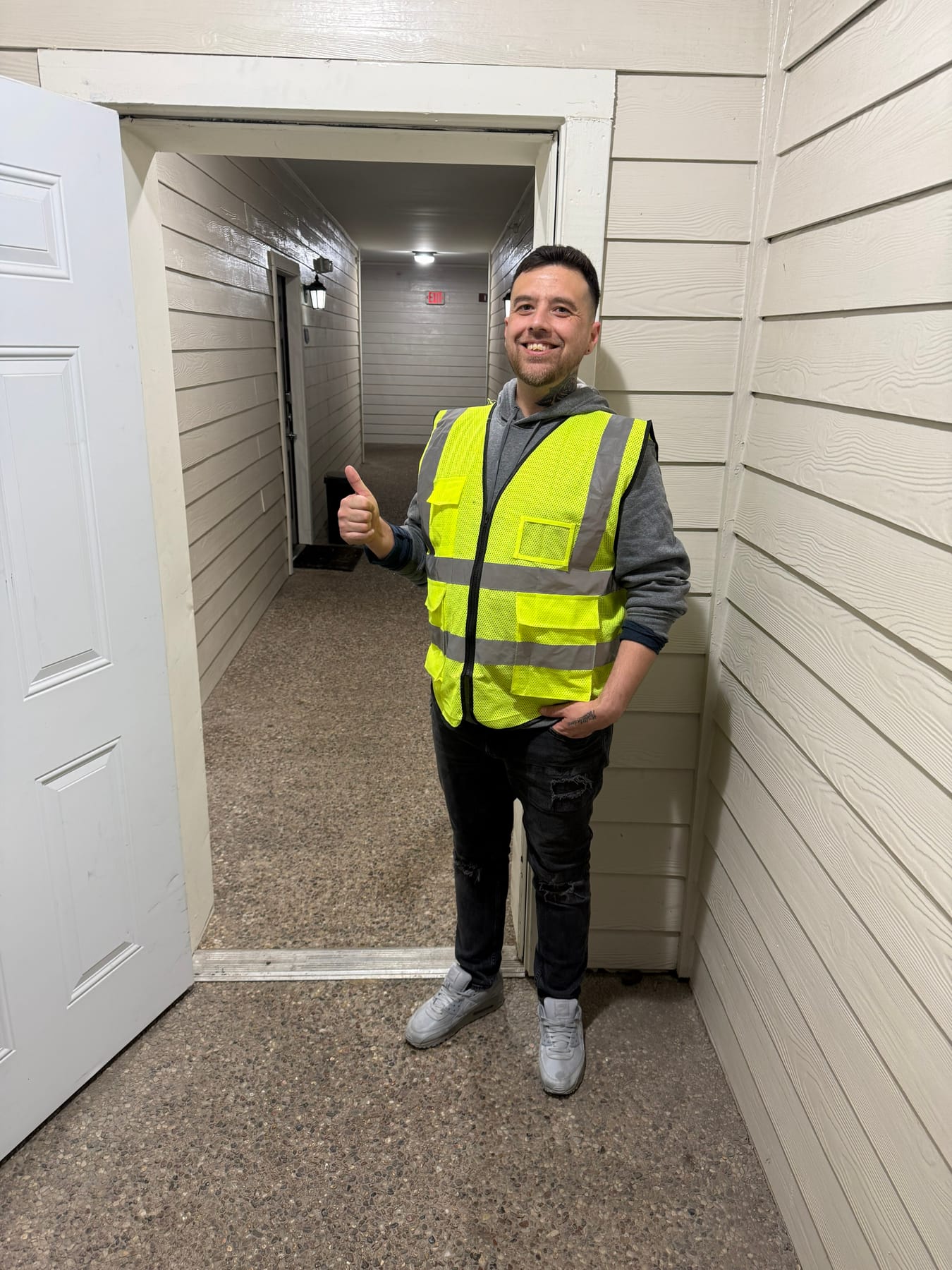 Daniel Montenegro giving a thumbs-up in an apartment breezeway